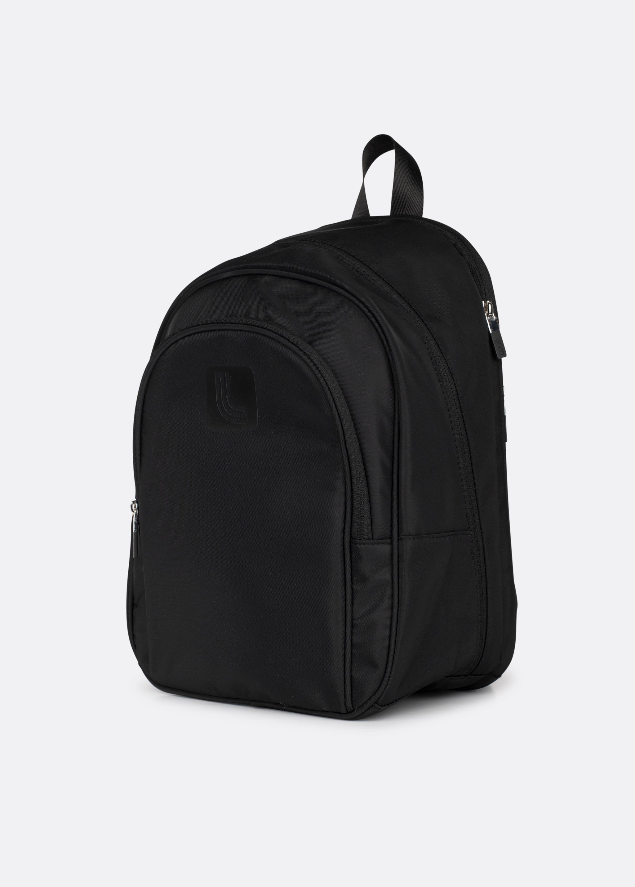 Lolë Chelsea backpack in black, three-quarter product shot showing the front zip pocket and rounded silhouette