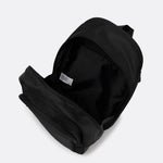 Lolë Chelsea backpack in black, unzipped and viewed from above to reveal the interior lining and front pocket