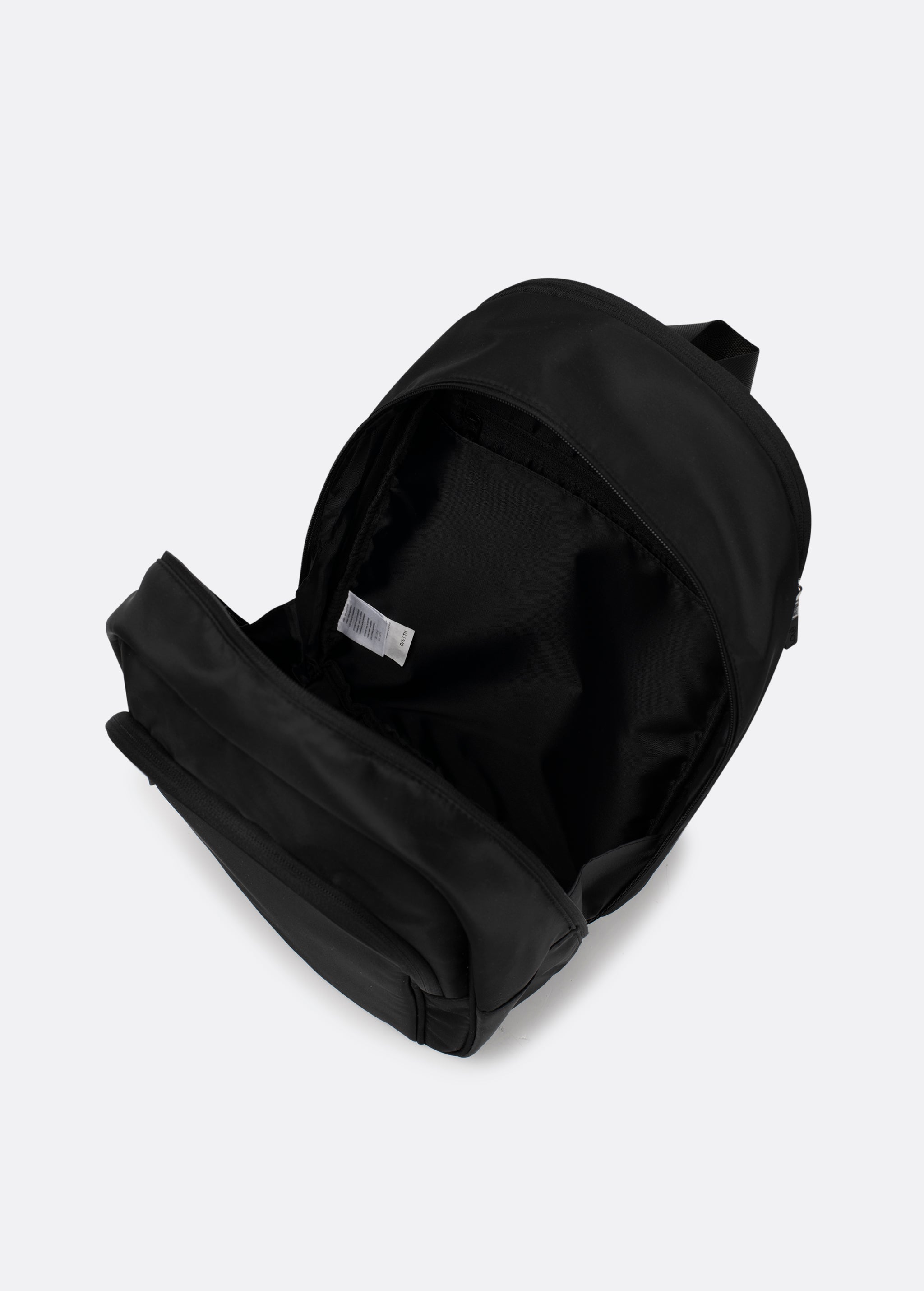 Lolë Chelsea backpack in black, unzipped and viewed from above to reveal the interior lining and front pocket