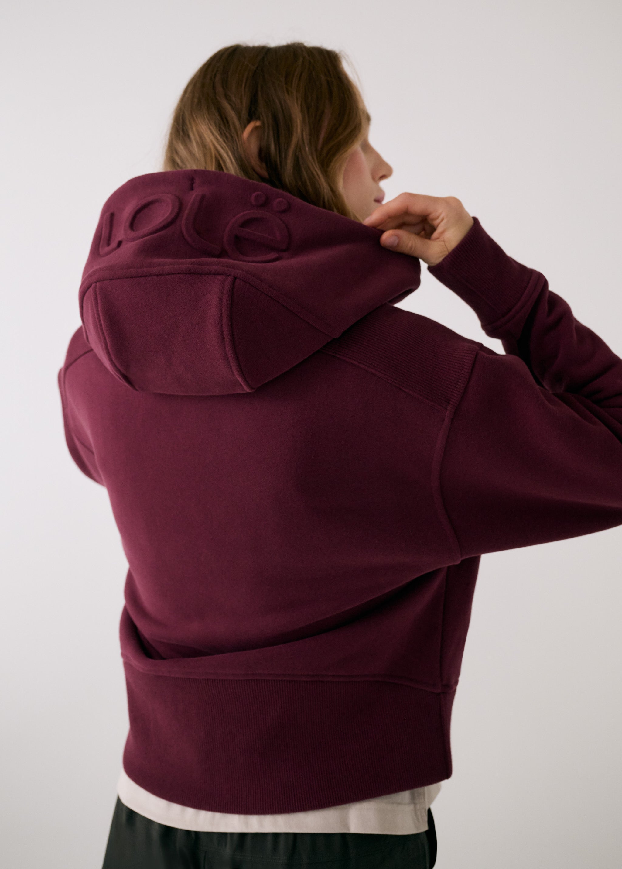 Lolë Yonder Full Zip Hoodie in burgundy — cropped and cozy, the Yonder Hoodie is your cold-weather comfort zone
