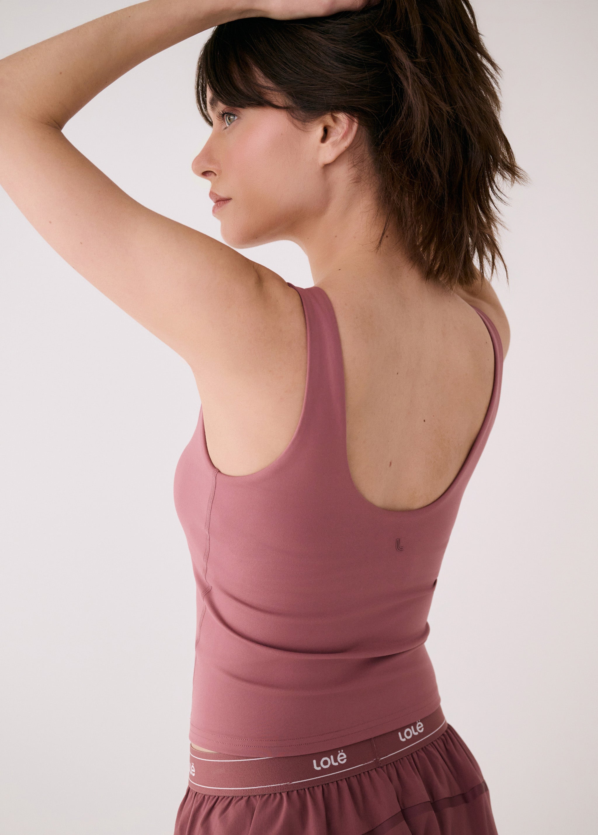 Lolë Serene Support tank top in berry, back view with low scoop neckline and logo