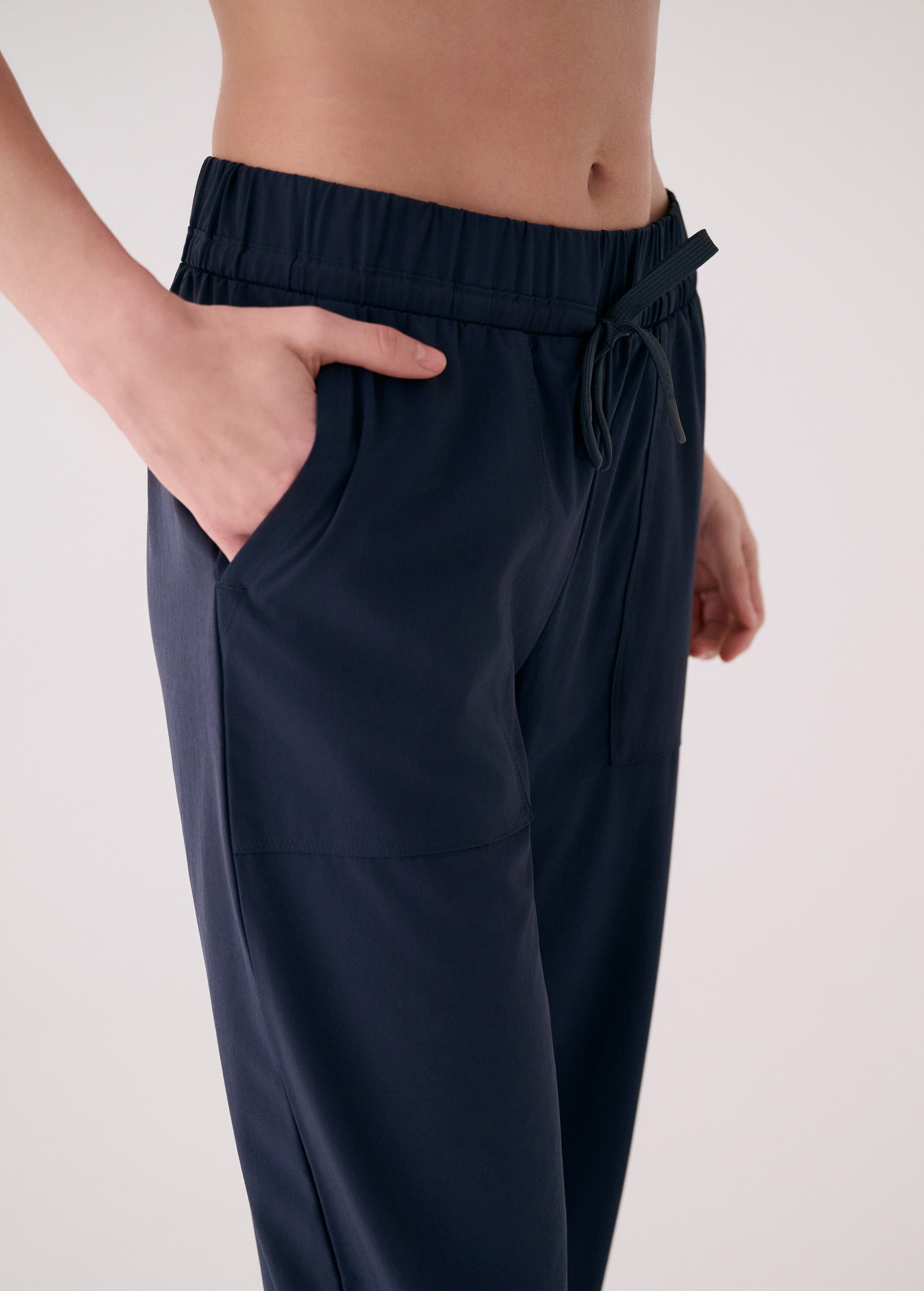 Lolë Olivie pants in navy, close view of the drawstring waist and side pocket