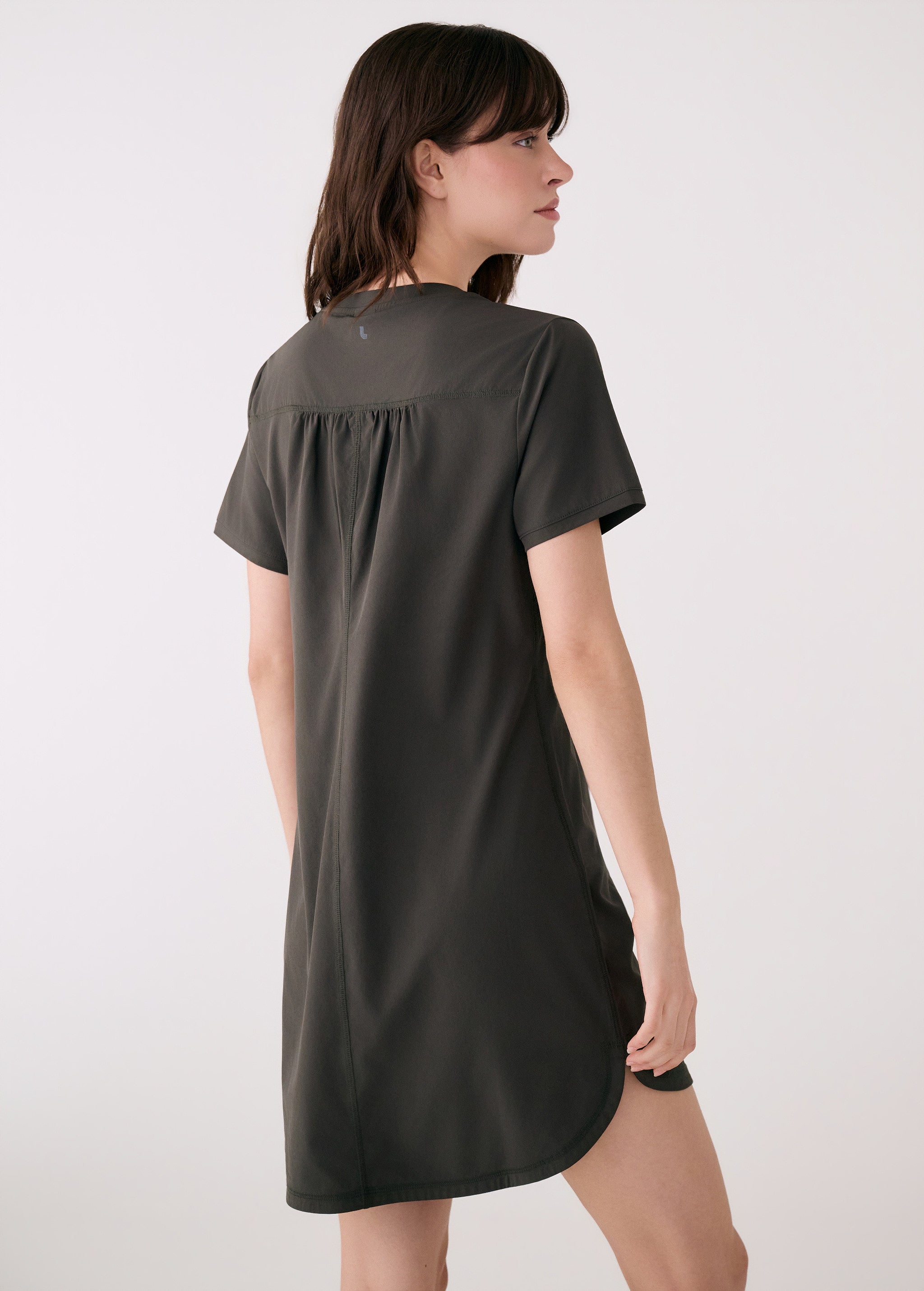 Lolë Olivie V-neck t-shirt dress in olive, back view with gathered yoke and curved shirttail hem