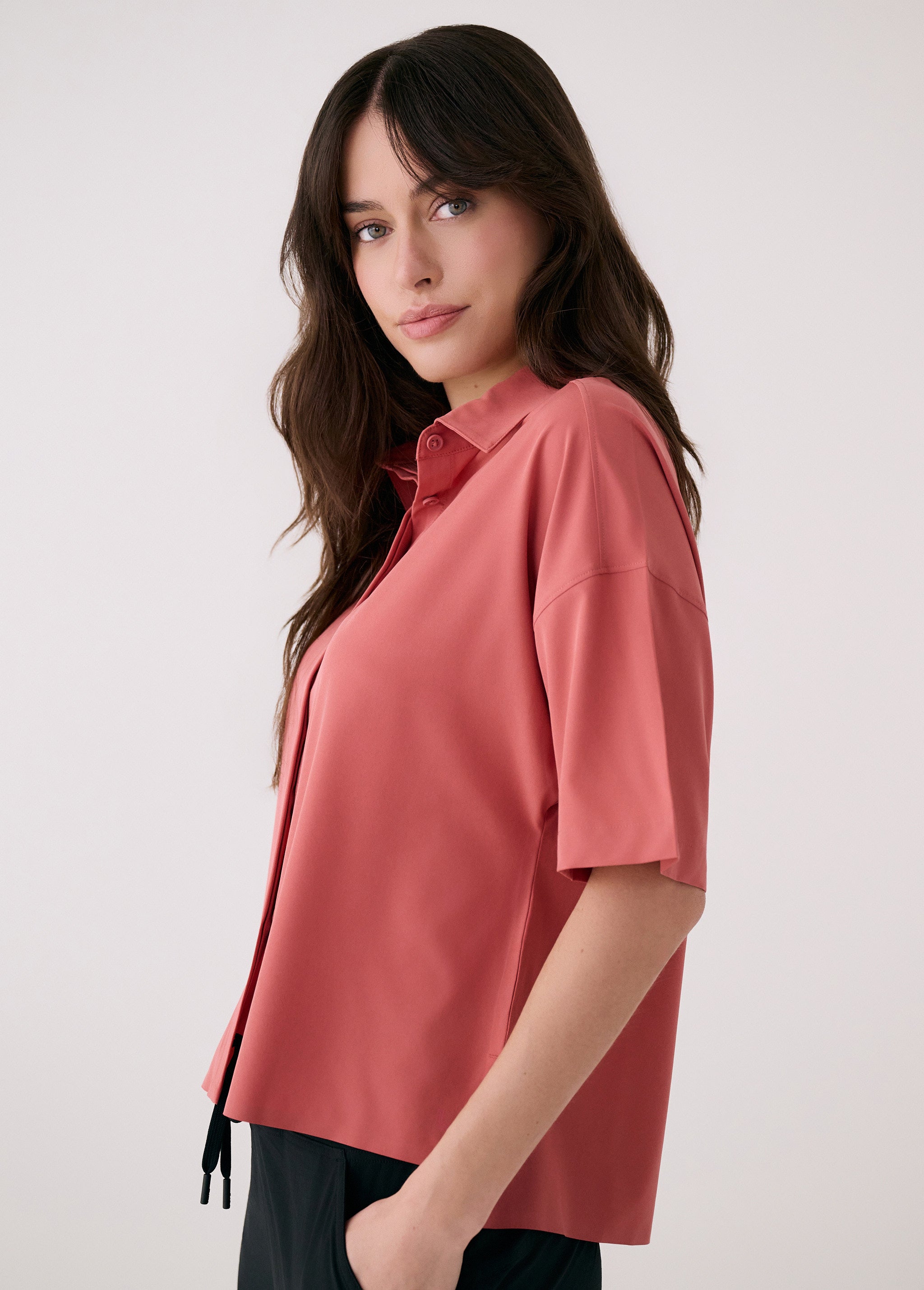 Lolë Olivie shirt in dusty rose, side view showing the relaxed boxy fit and drawstring hem