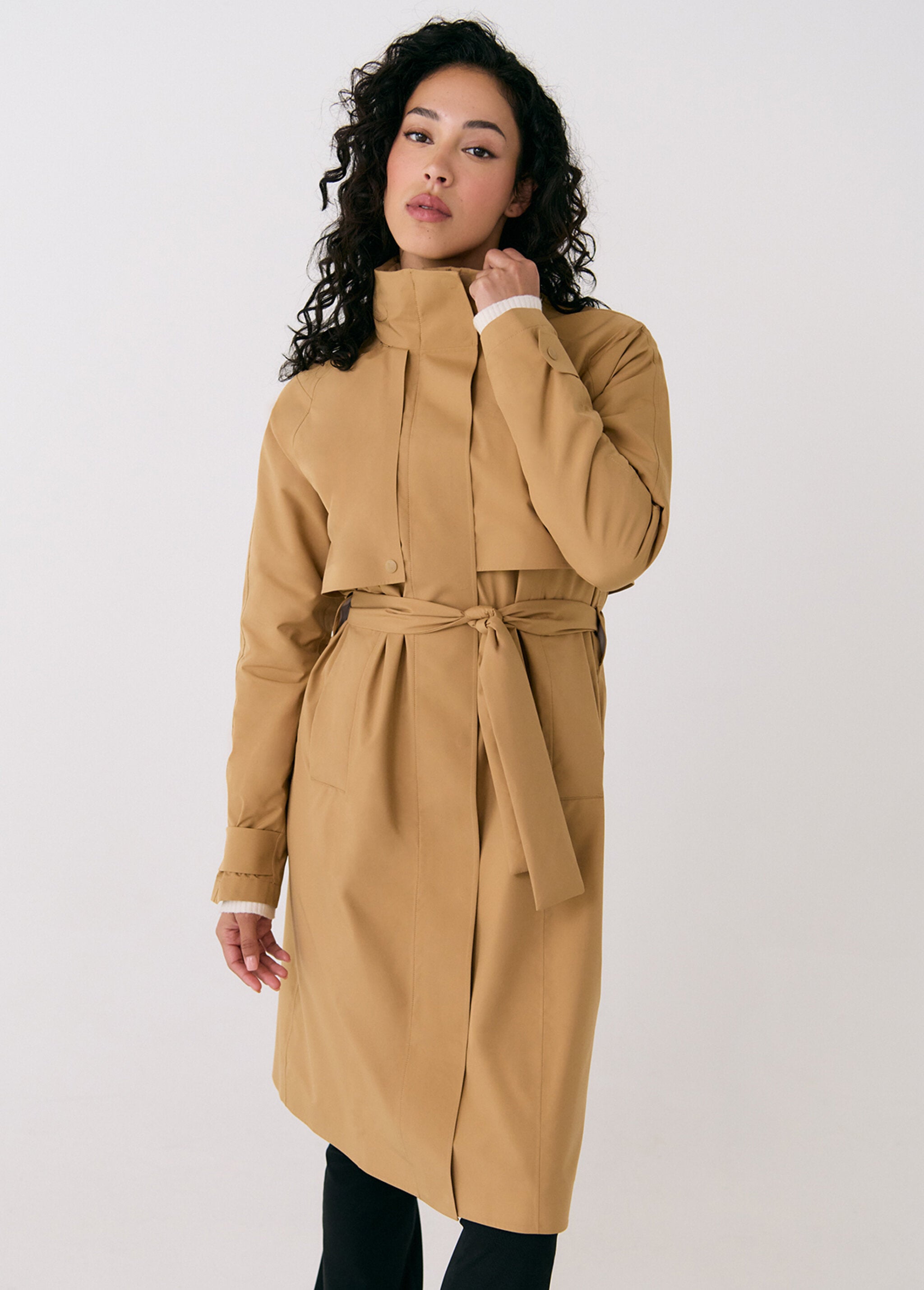 Lolë Alizé rain trench coat in camel, front view on model — belted with a tie waist