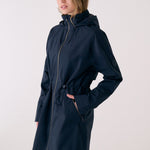 Lolë Piper 2.0 rain jacket in navy, side view showing the front zip, drawcord waist and flap zip pocket