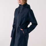 Lolë Piper 2.0 rain jacket in navy, side view showing the front zip, drawcord waist and flap zip pocket