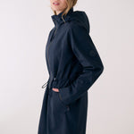Lolë Piper 2.0 rain jacket in navy, side view with hood-up collar, sleeve logo and drawcord at the waist