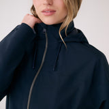 Lolë Piper 2.0 rain jacket in navy, close view of the two-way front zip and drawcord toggles at the neck