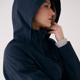 Lolë Piper 2.0 rain jacket in navy, hood-up close-up showing the funnel neck and buttoned cuff