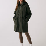 Lolë Piper 2.0 rain jacket in olive green, full-length front view zipped up with hood and drawcord waist