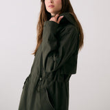 Lolë Piper 2.0 rain jacket in olive green, side view showing the drawcord waist, zip pocket and cuff