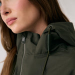 Lolë Piper 2.0 rain jacket in olive green, close-up of the funnel neck zip and branded hood cord pull