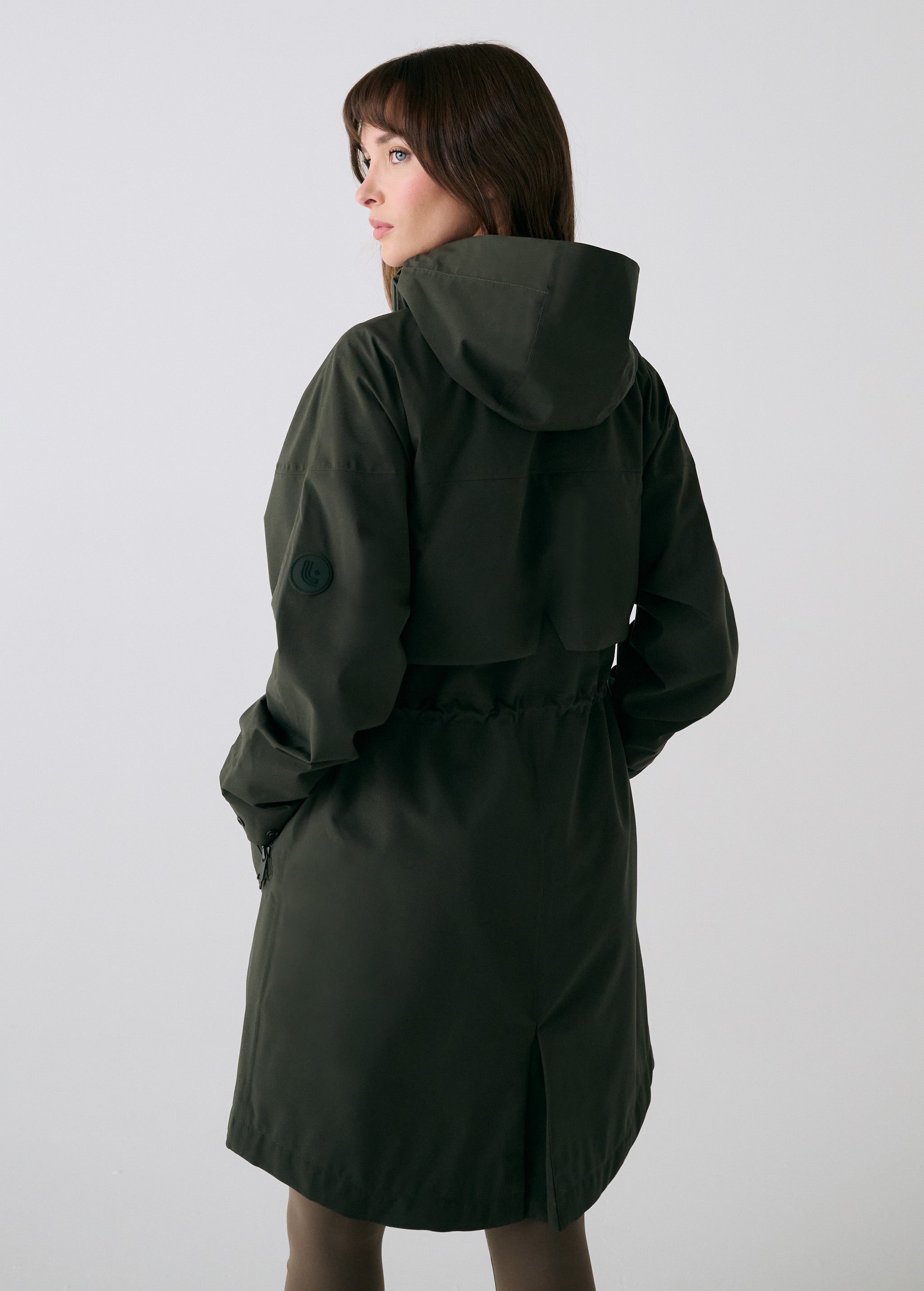 Lolë Piper 2.0 rain jacket in olive green, back view with hood, back yoke and gathered drawcord waist