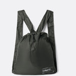 Lolë Piper 2.0 rain jacket in olive green, folded flat into its matching drawstring backpack pouch