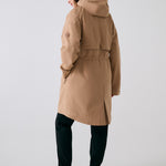 Lolë Piper 2.0 rain jacket in camel, rear view with the hood, back yoke and drawcord-gathered waist