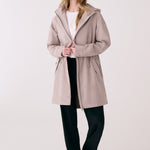 Lolë Piper 2.0 rain jacket in taupe, worn open over a white tee, full front view with hood and drawcord waist