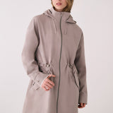 Lolë Piper 2.0 rain jacket in taupe, front view zipped up showing the hood, two-way zip and drawcord waist