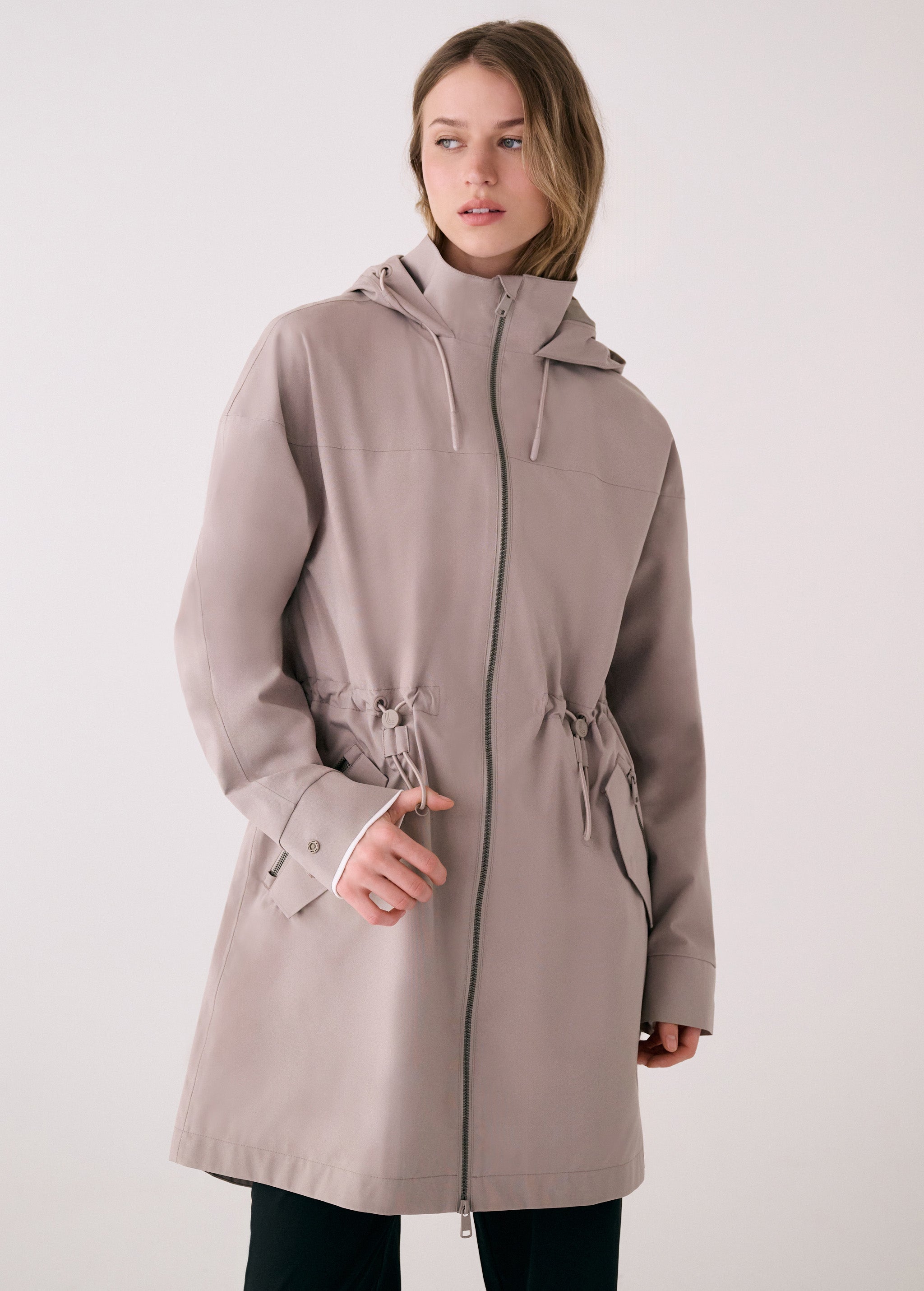 Lolë Piper 2.0 rain jacket in taupe, front view zipped up showing the hood, two-way zip and drawcord waist