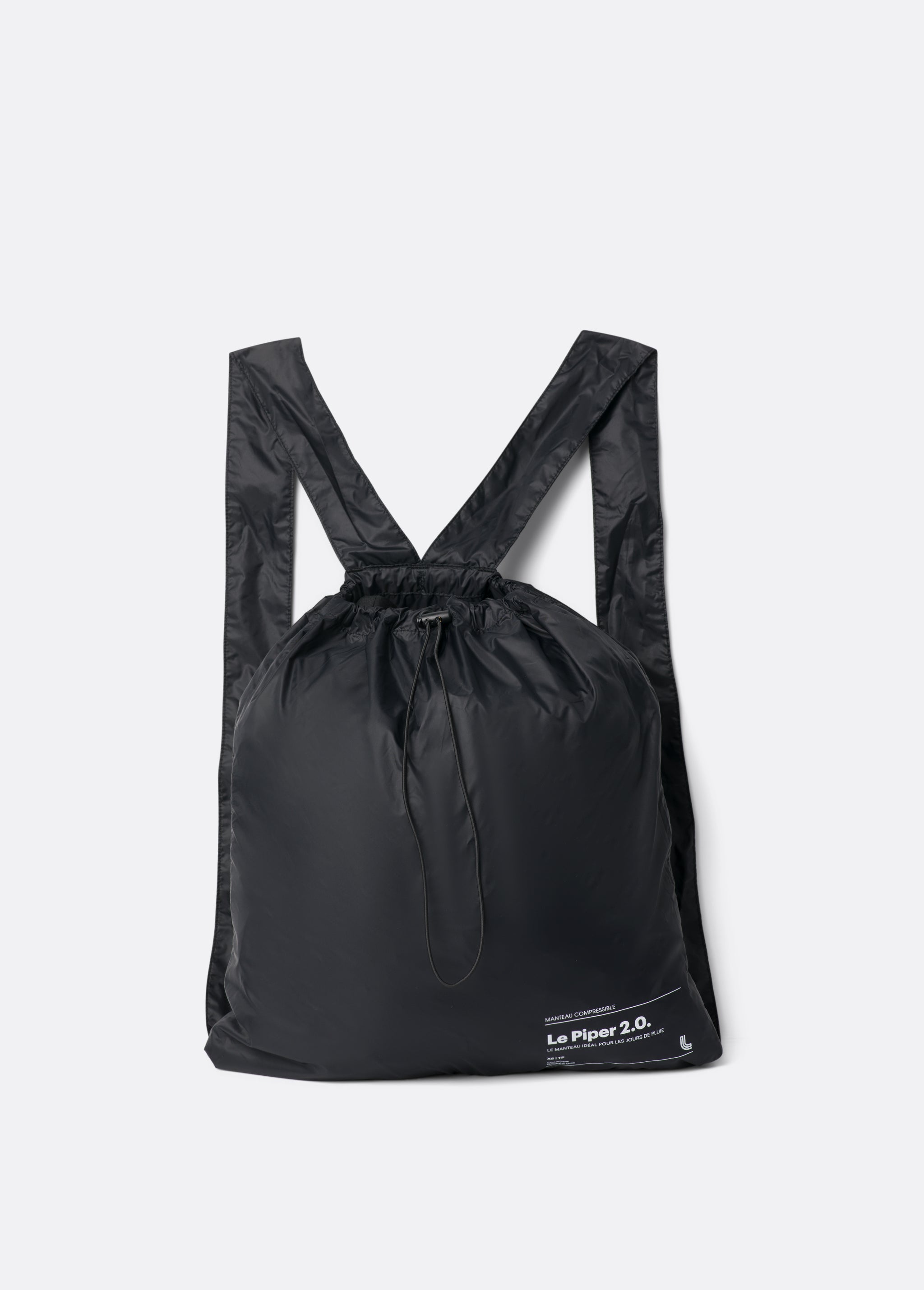 Lolë Piper 2.0 rain jacket in black, packed into its matching drawstring backpack pouch, laid flat