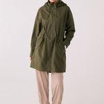 Lolë Piper 2.0 rain jacket in olive green, full front view zipped up with hood and drawcord waist