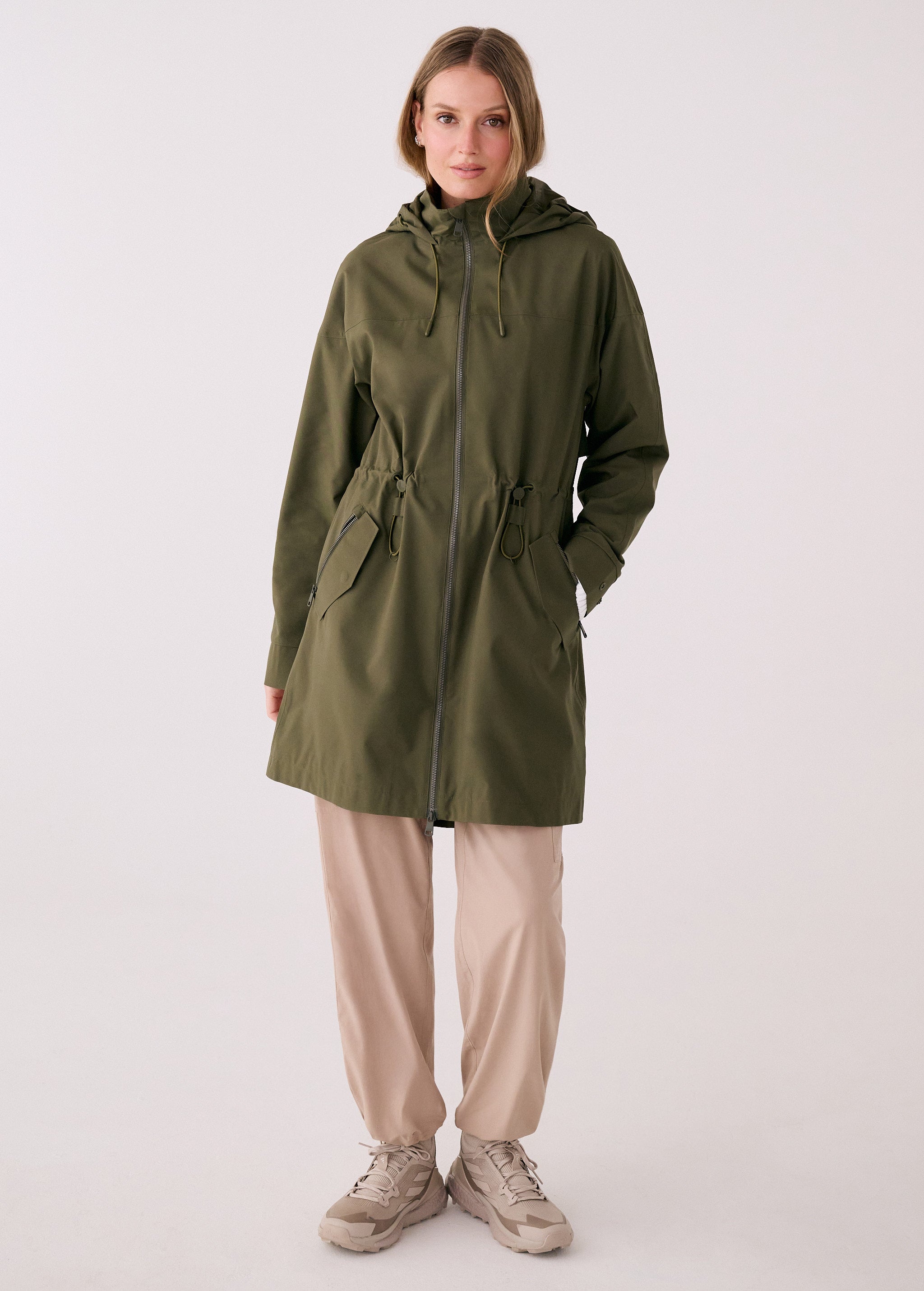 Lolë Piper 2.0 rain jacket in olive green, full front view zipped up with hood and drawcord waist
