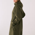 Lolë Piper 2.0 rain jacket in olive green, side view showing the hood, sleeve logo and side hem vent