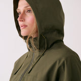 Lolë Piper 2.0 rain jacket in olive green, close-up with the hood up and front zip drawn to the chin