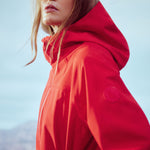 Lolë Element Long Rain Jacket in Poppy red — this longline jacket keeps water out while keeping your look sharp