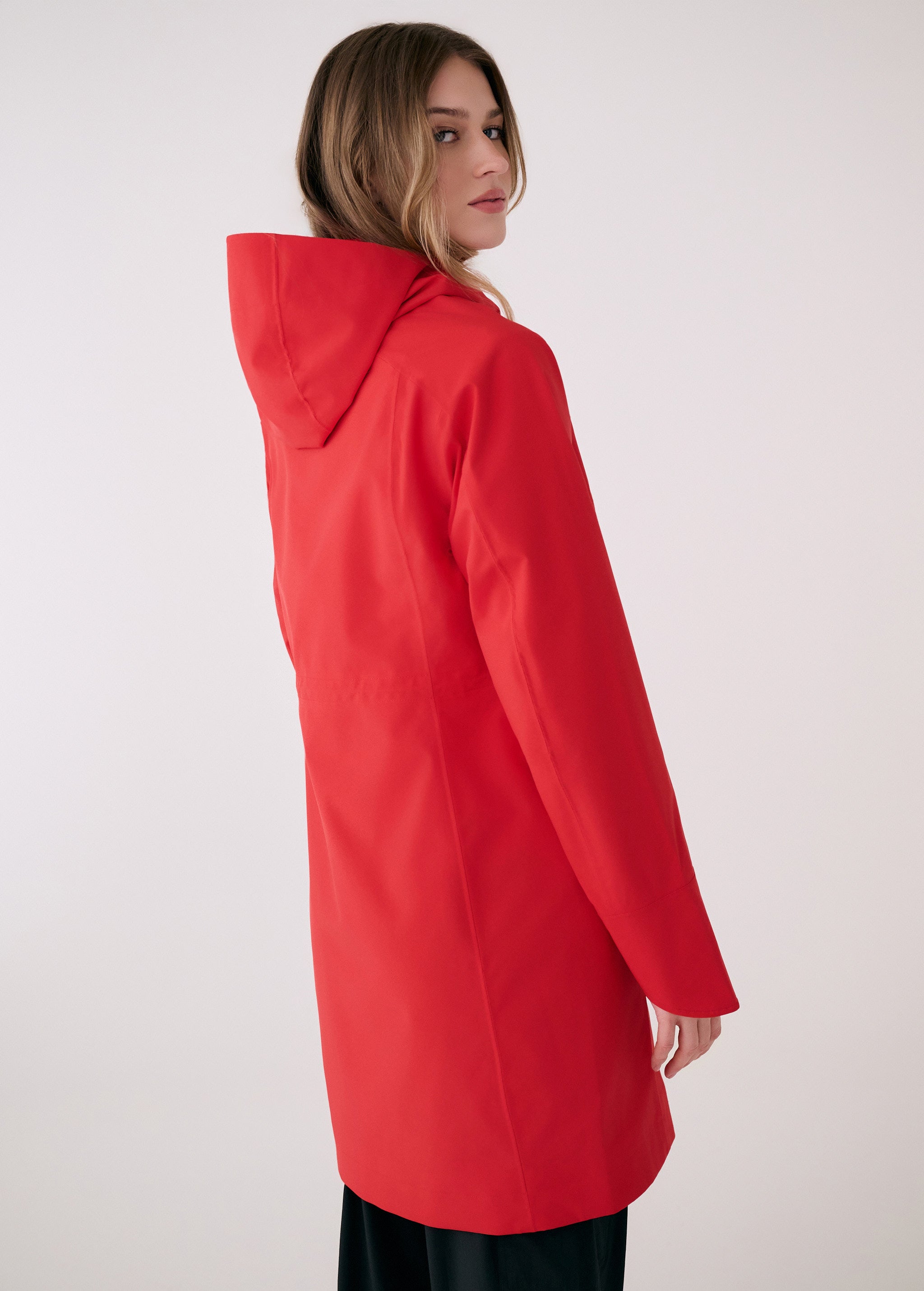 Lolë Element Long Rain Jacket in Poppy red — this longline jacket keeps water out while keeping your look sharp