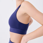 Lolë Power Sport Bra in Dusk navy — a thick branded strap and hook-and-eye closure serve maximum support