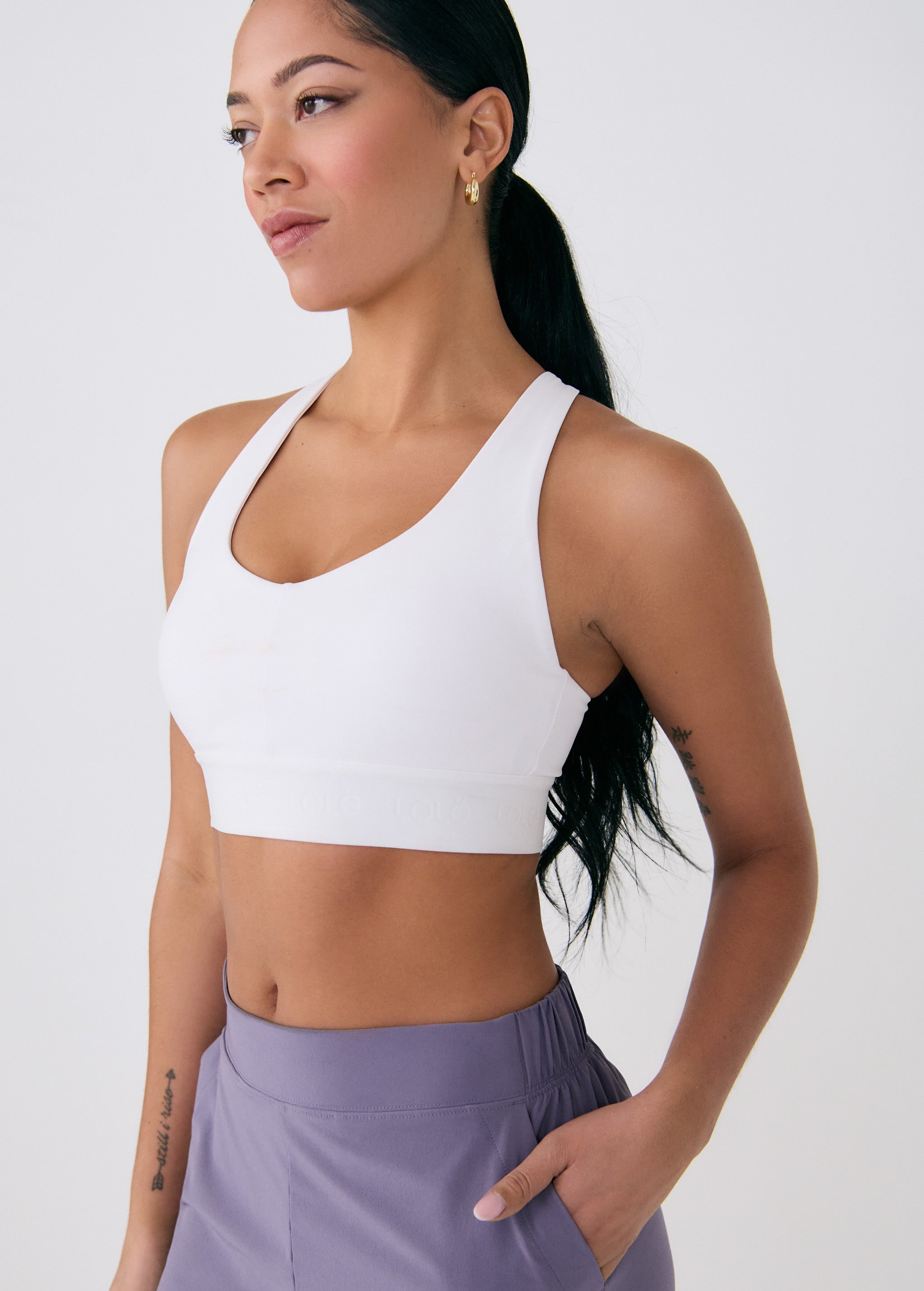 Lolë Power Sport Bra in white — a thick branded strap and hook-and-eye closure serve maximum support