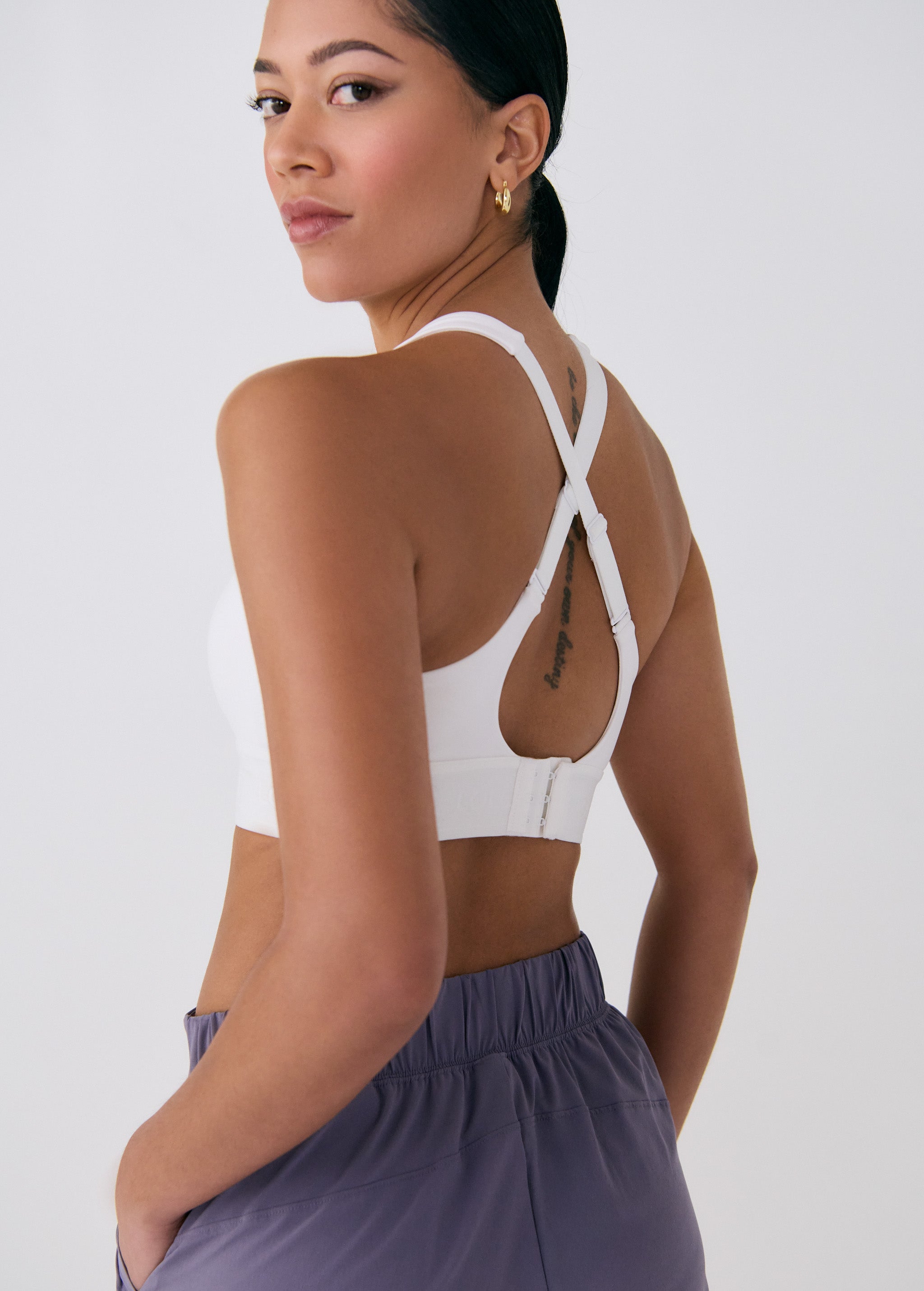 Lolë Power Sport Bra in white — a thick branded strap and hook-and-eye closure serve maximum support