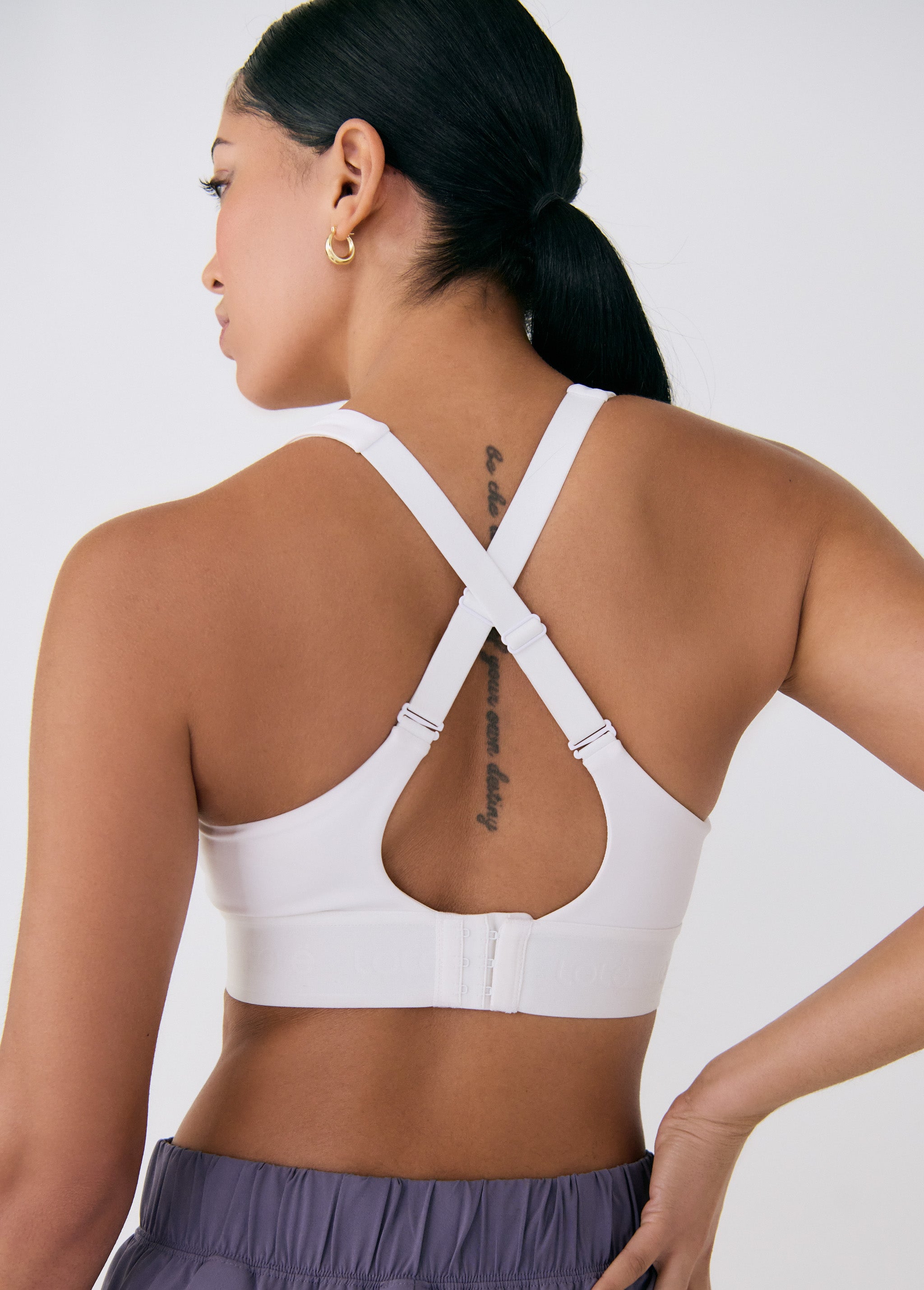 Lolë Power Sport Bra in white — a thick branded strap and hook-and-eye closure serve maximum support
