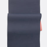 Lolë Pose yoga mat in navy, unrolled flat revealing the navy top and dusty pink underside