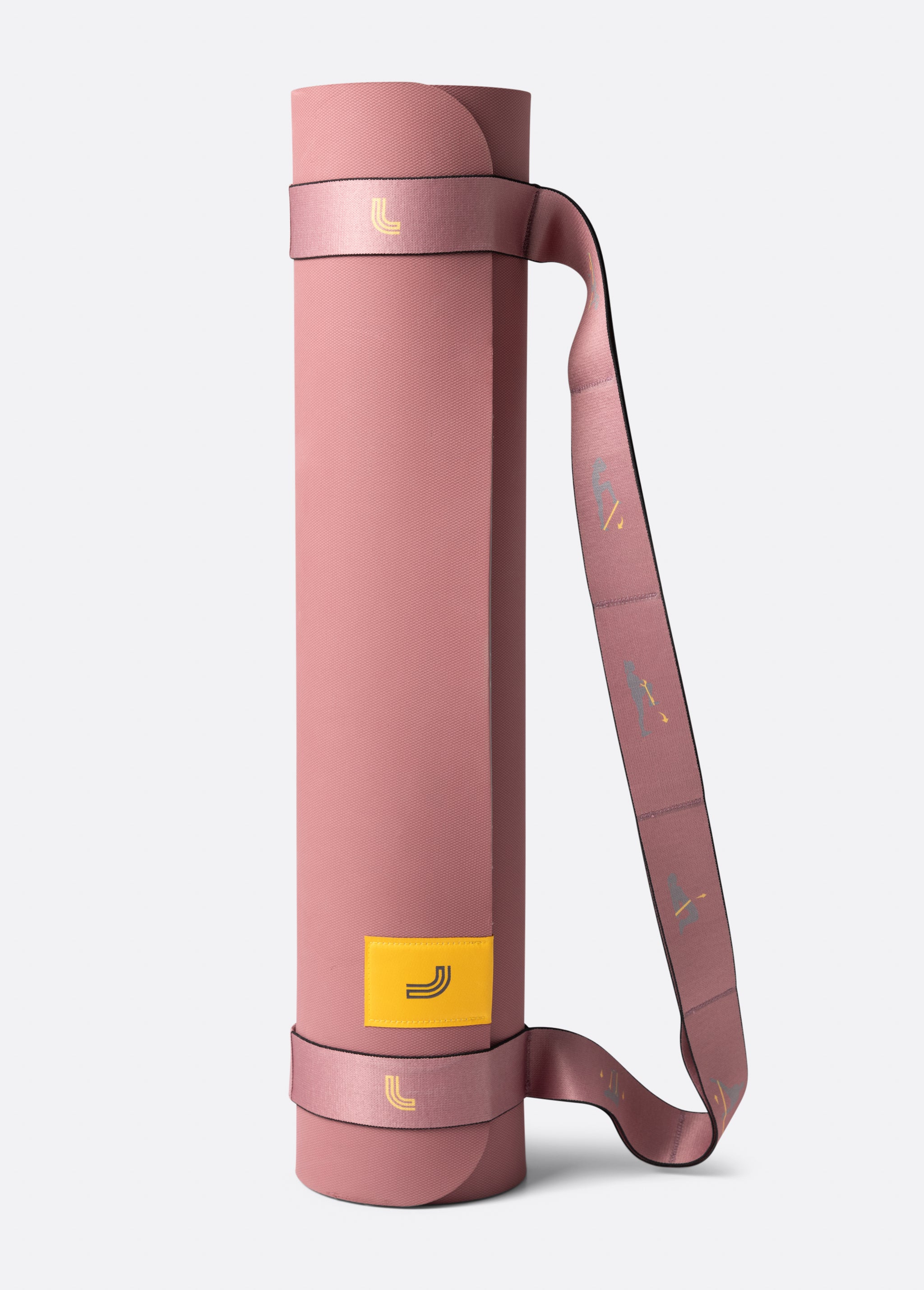 Lolë Pose yoga mat in dusty pink, rolled upright with the matching pink carry strap wrapped around it