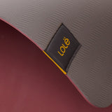 Lolë Pose yoga mat in grey, close-up of the folded edge where the grey top meets the burgundy underside