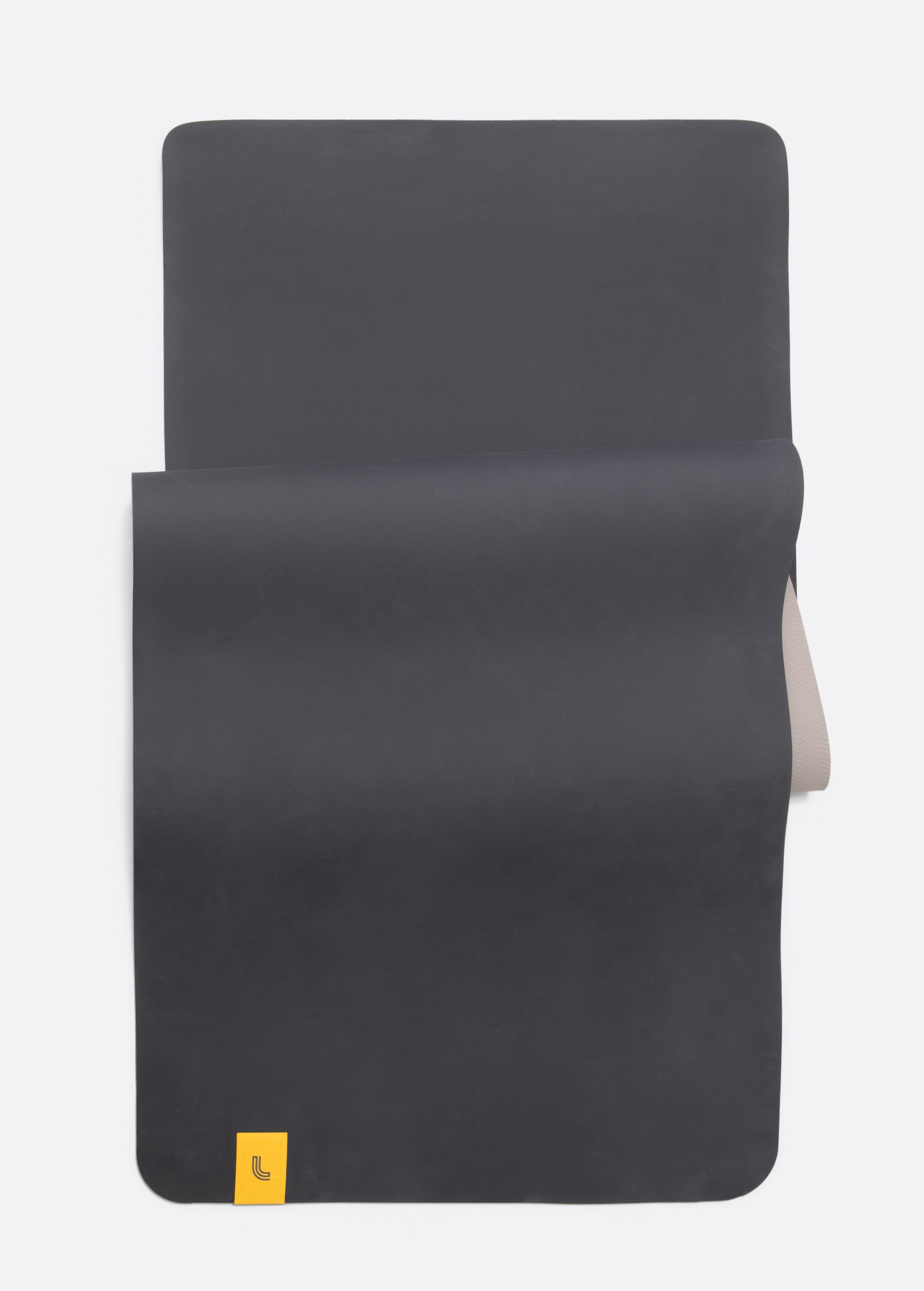 Lolë Pose yoga mat in taupe, laid flat and folded back to reveal the charcoal underside beneath the taupe top