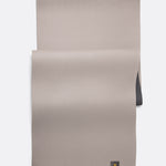 Lolë Pose yoga mat in taupe, unrolled flat with a corner turned over showing the charcoal underside