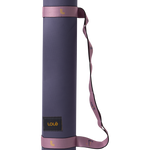 Lolë Pose yoga mat in navy, rolled upright showing the navy outer side with the mauve-pink carry strap
