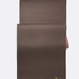 Lolë Pose yoga mat in chocolate brown, laid flat with the brown surface up and dusty rose underside at the edge