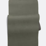 Lolë Pose yoga mat in olive green, unrolled flat showing the olive top and charcoal underside at the roll edge