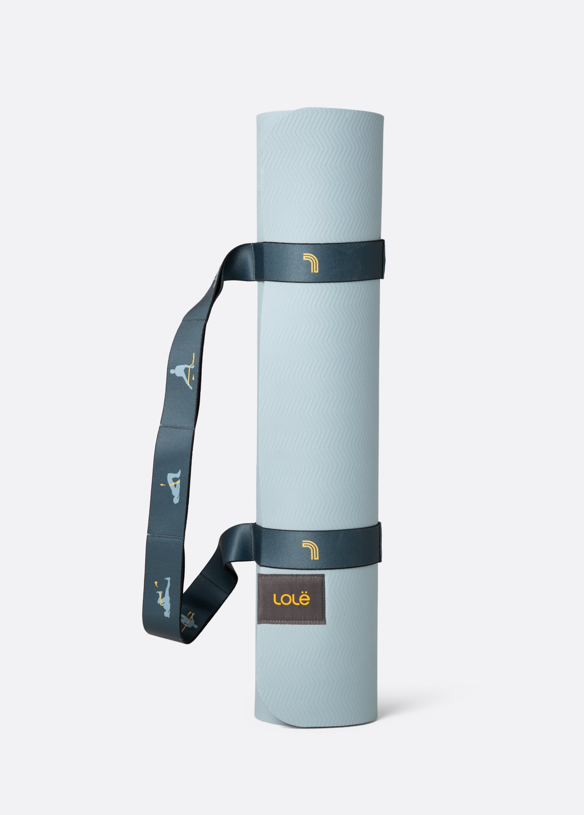 Lolë Pose yoga mat in pale ice blue, rolled and secured with the dark teal carry strap
